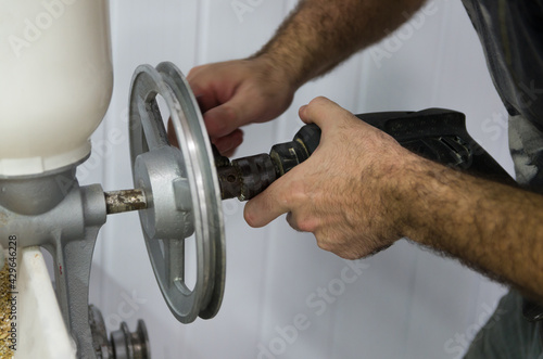 Homebrewer setting up a malt mill to grind with the aid of a dri