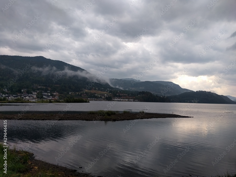 clouds over the lake with view of small town