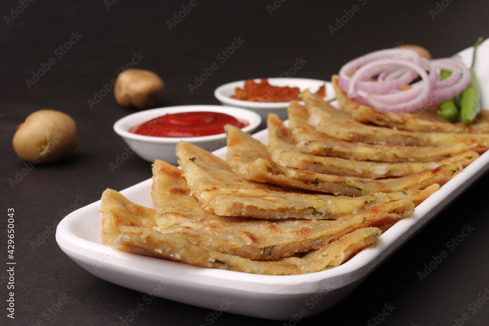 Traditional Indian food Aloo paratha or potato stuffed flat bread. served with pickle tomato ketchup and curd, butter, onion chili. Traditional Indian food Aloo paratha or potato stuffed flat bread. served with pickle tomato ketchup and curd, butter, onion chili.