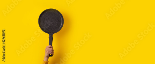 Wallpaper Mural granite pan in hand over yellow background, panoramic mock-up with space for text Torontodigital.ca