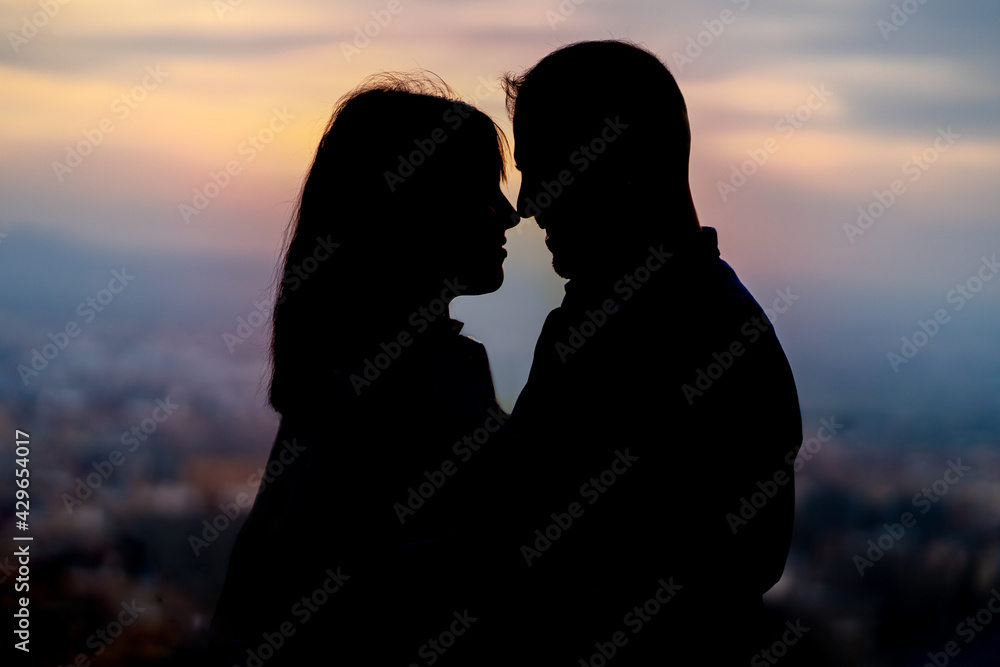 backlighting of a couple in love creating a silhouette in the sunset