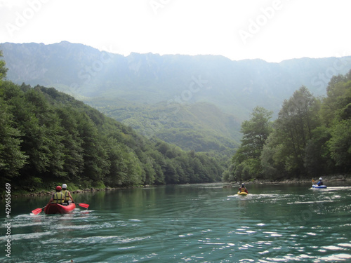 Canoeists and kayakers on the river in a mountain landscape