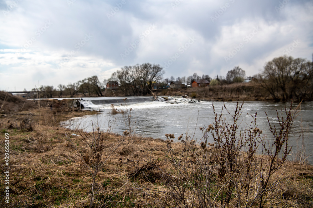 spring landscape with river and trees on the background of spring clouds 