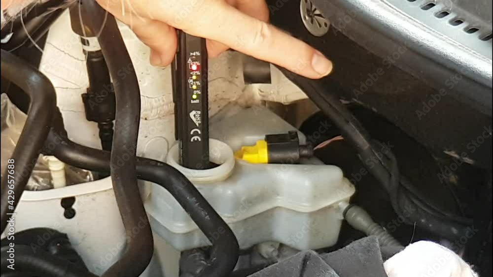 Showing how to use a brake fluid tester on a car. Incl result = red