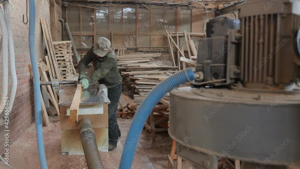 Carpenter working in his own woodshop. He is working with sawmill. Small business concept Carpenter working in his own woodshop. He is working with sawmill. Small business concept