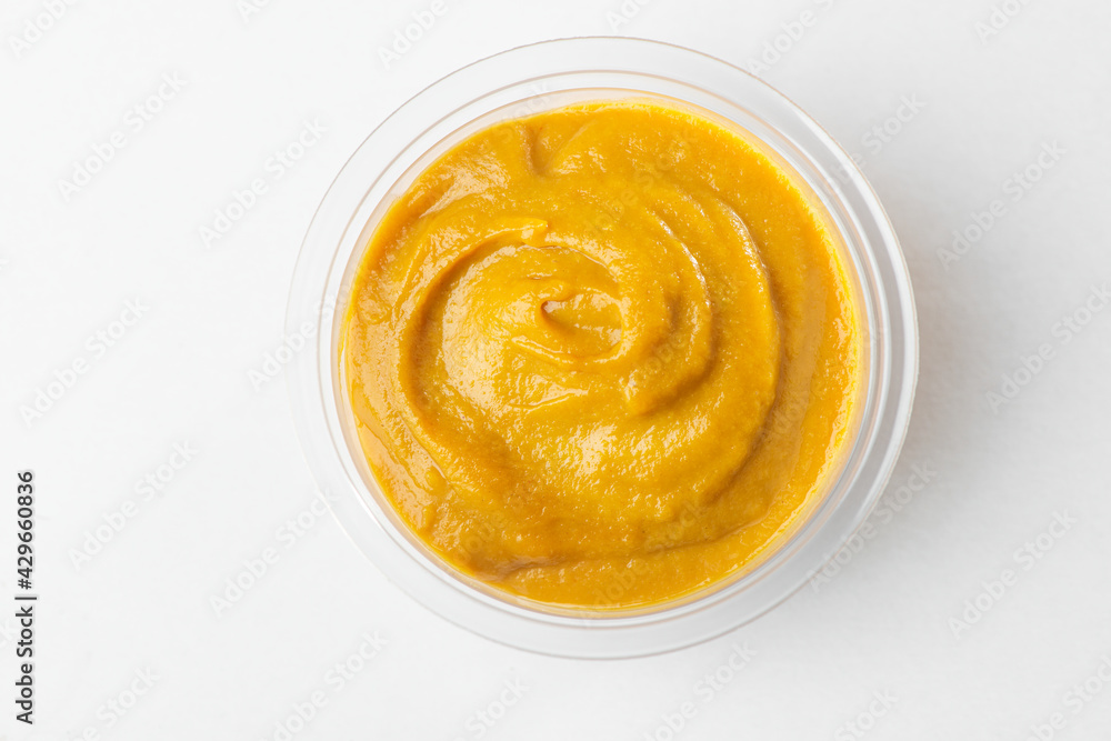 Top view on a cup of liquid mustard on white background Top view on a cup of liquid mustard on white background