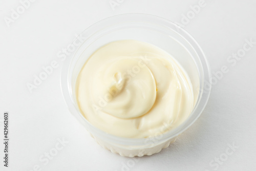 Close-up on a cup of mayonnaise on white background