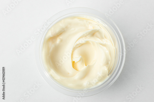 Top view on a cup of mayonnaise on white background