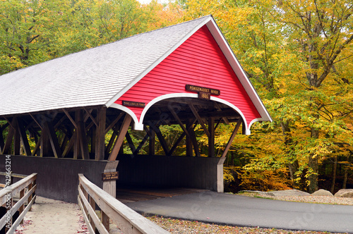 The Flume Gorge Covered Bridge is surrounded by autumn color in New England