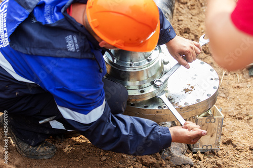 a man working in uniform is engaged in repairing the gas pipe, repairing the equipment with tools, iron communications repair gasman, improving their condition and improving the safety of people, unsc photo