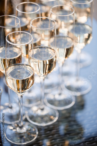 Glass goblets filled with sparkling champagne and stand on the table