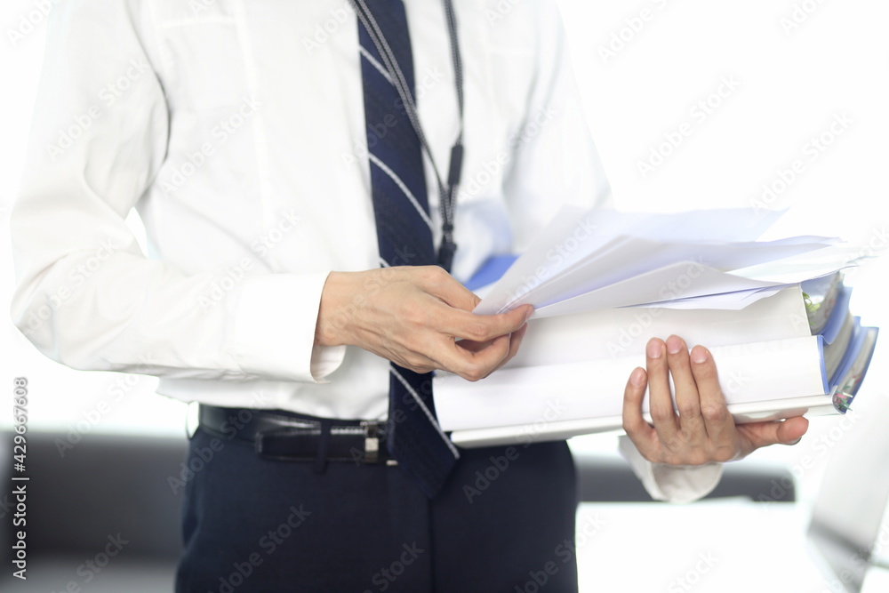 Businessman holding files with paperwork Businessman holding files with paperwork