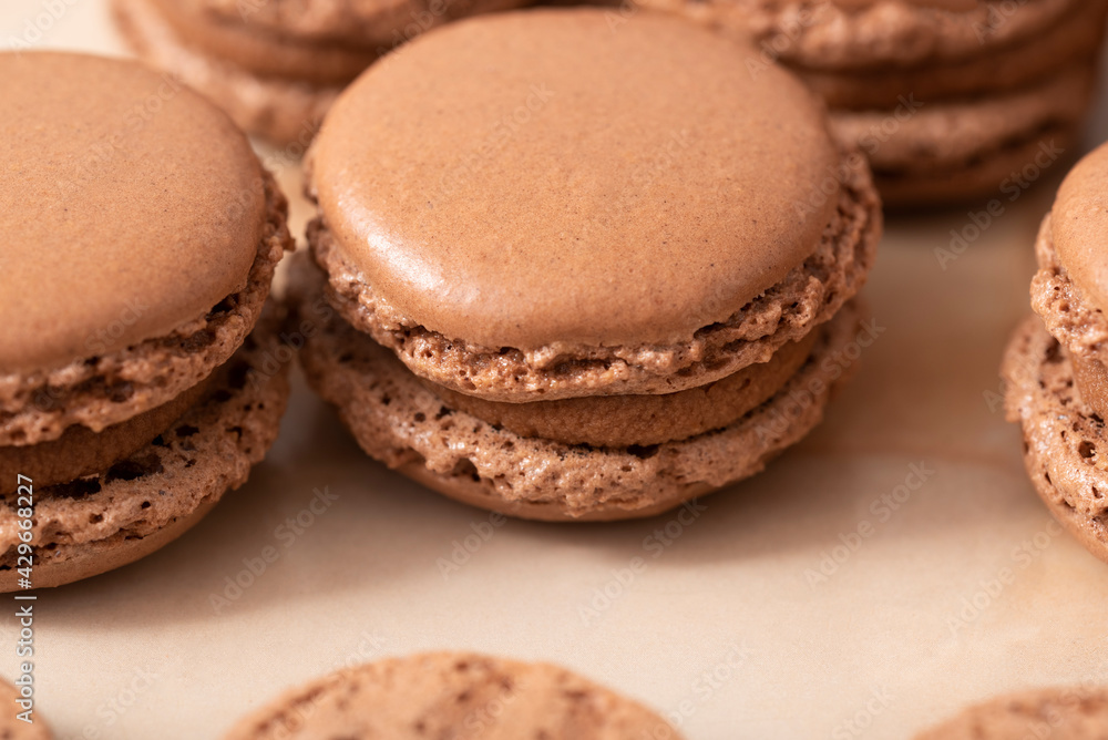 brown macarons with chocolate cream, on a wooden table