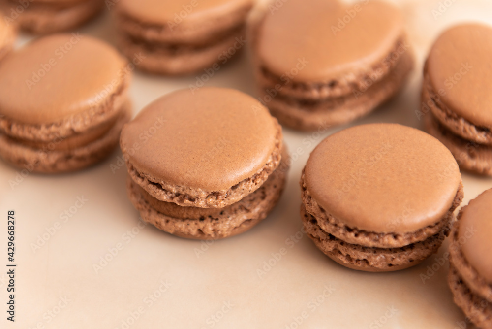 brown macarons with chocolate cream, on a wooden table brown macarons with chocolate cream, on a wooden table