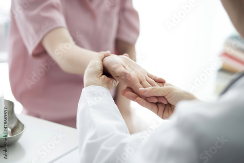 Doctor checking patient's hand pain photo
