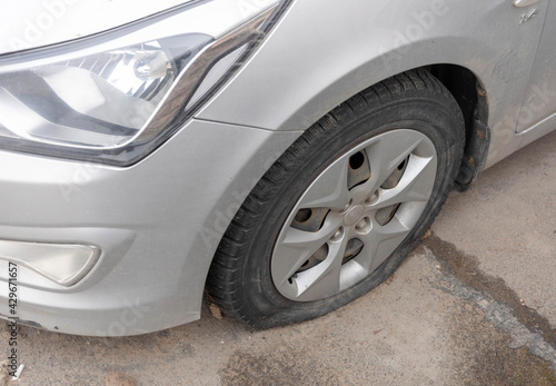 Flattened car tire after a car wheel puncture  requires repair