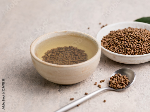 Top view of healthy soba tea and groats of tartary buckwheat Ku Qiao seeds on light background. Flat lay. Copy space