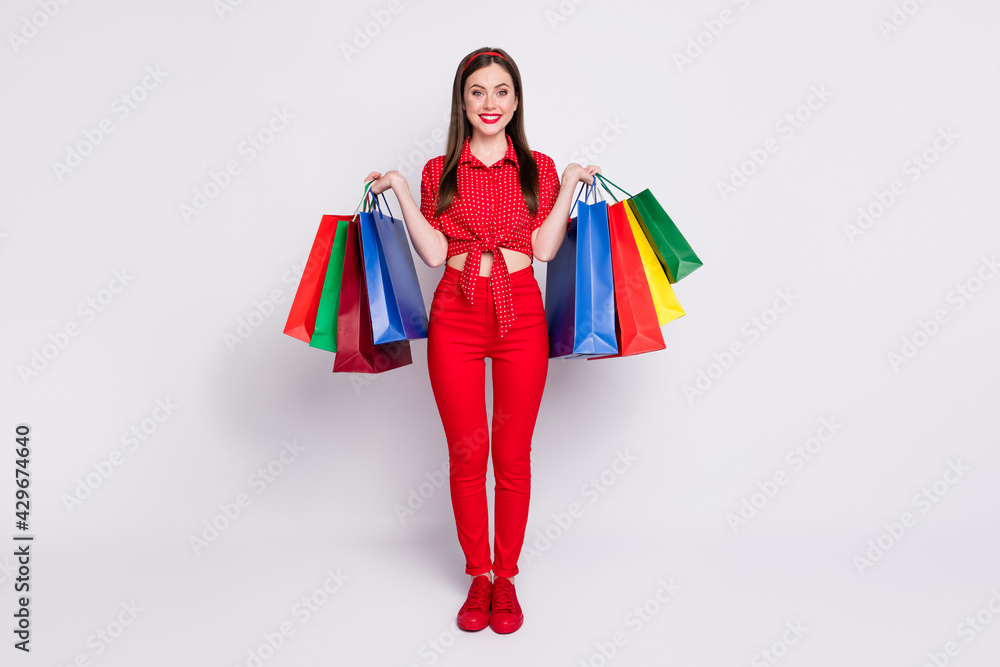 Photo of charming young girl hold many packages wear red dotted blouse trousers footwear isolated grey color background Photo of charming young girl hold many packages wear red dotted blouse trousers footwear isolated grey color background