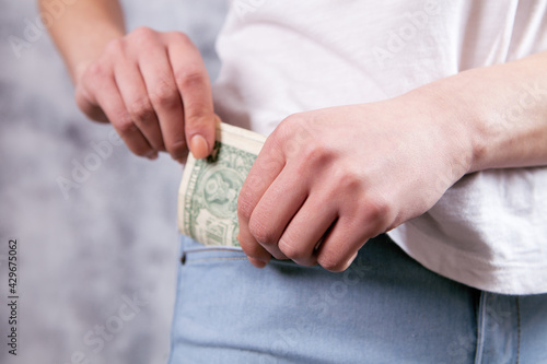 girl hand putting money in jeans pocket
