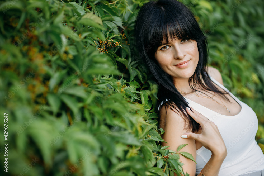 Close up portrait of cute mysterious brunette girl with green leaves. Beauty, cosmetics Close up portrait of cute mysterious brunette girl with green leaves. Beauty, cosmetics