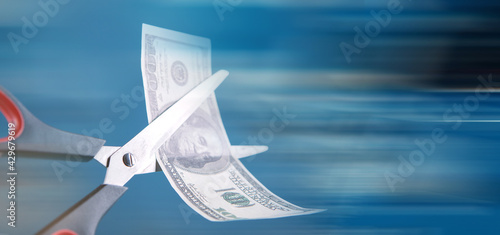 Scissors cut a dollar bill in half