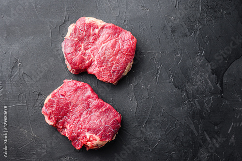 Fresh beef Rump steaks over black background, top view with space for text.