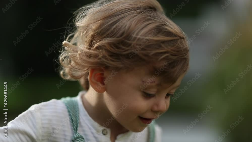Baby toddler boy with curly hair feeling the wind blow outside Baby toddler boy with curly hair feeling the wind blow outside