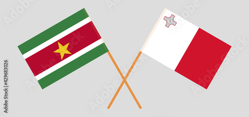 Crossed flags of Suriname and Malta. Official colors. Correct proportion