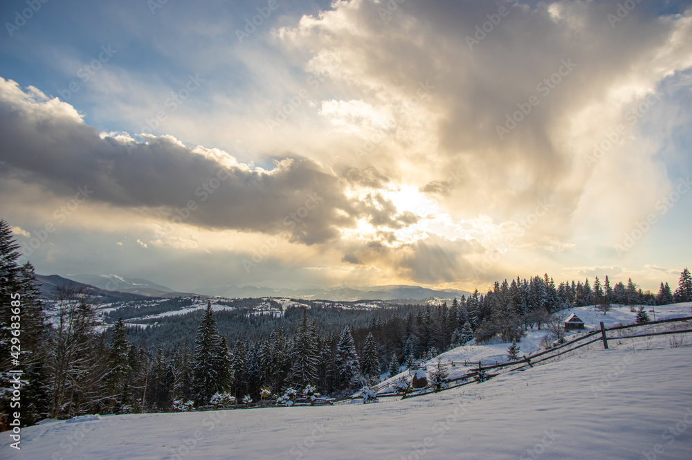 Panorama of a village in winter in the mountains at sunset