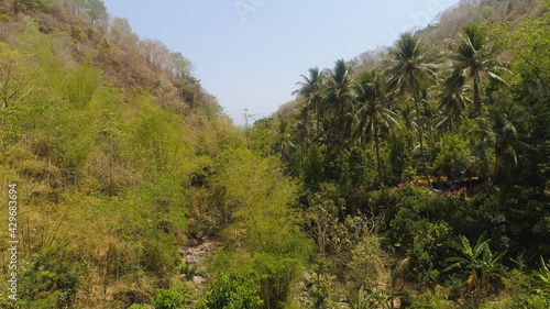 aerial view slopes mountains covered with forest and vegetation against blue sky. mountain hilly landscape in asia. tropical landscape