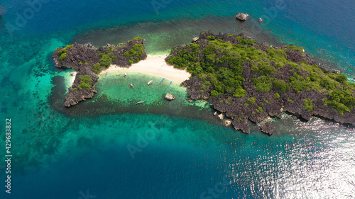 Tropical island with sandy with tourists and blue sea, aerial view. Lahos Island, Caramoan Islands, Philippines. Summer and travel vacation concept.