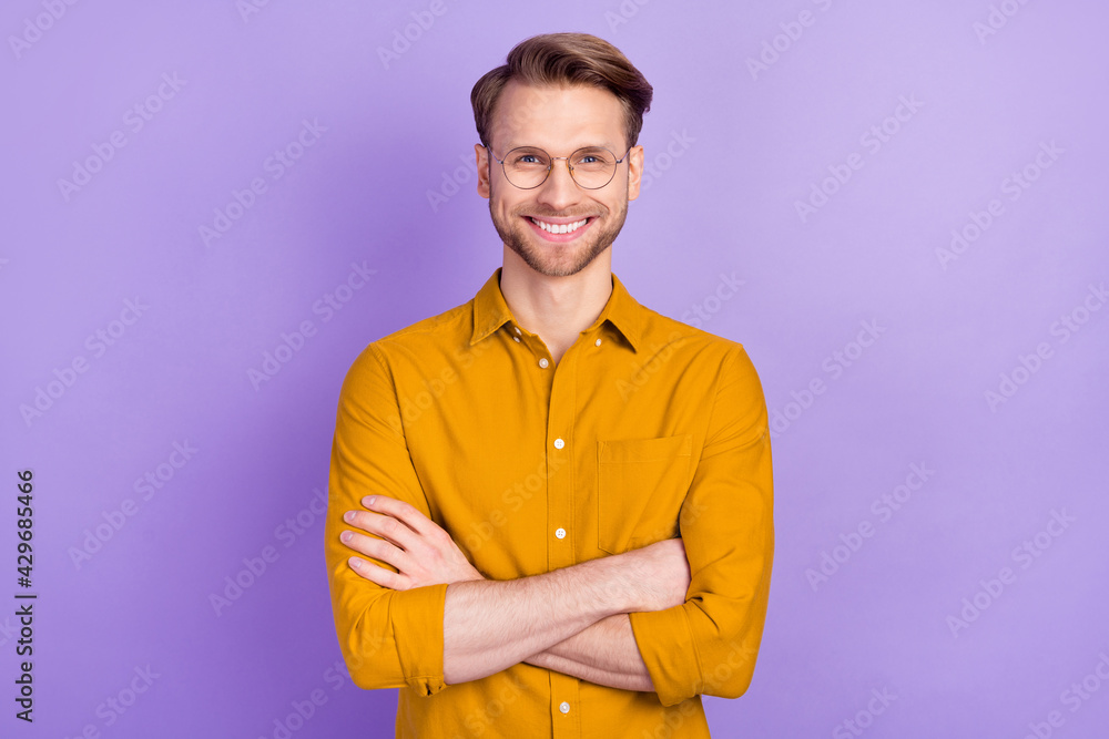 Photo of satisfied friendly man folded arms toothy smile look camera isolated on violet color background Photo of satisfied friendly man folded arms toothy smile look camera isolated on violet color background