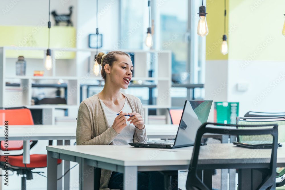 Blonde businesswoman ( employee ) working on a laptop in a modern office. Blonde businesswoman ( employee ) working on a laptop in a modern office.