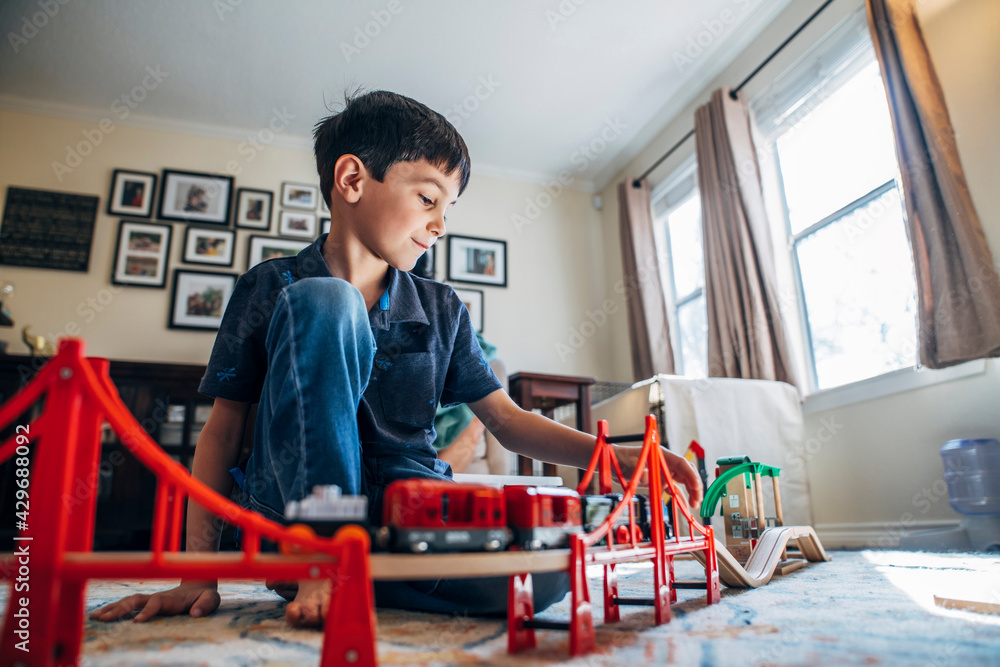 Boy playing with toy train in living room Boy playing with toy train in living room