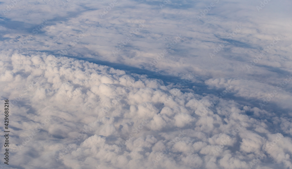 Stratosphere, a view of clouds from an airplane window. Cumuliform cloudscape on sky. Flying over the land. Stratosphere, a view of clouds from an airplane window. Cumuliform cloudscape on sky. Flying over the land.