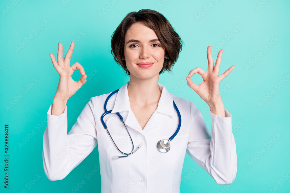 Photo of young woman happy positive smile doctor therapist show okey cool sign isolated over teal color background