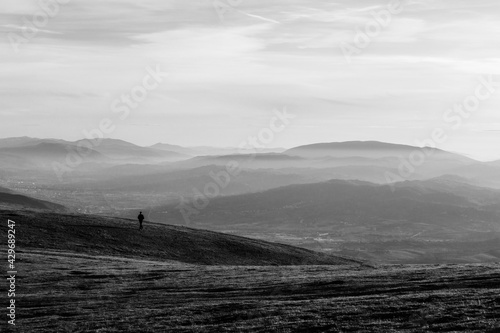 A distant man on a mountain, with mist, fog and layers of mountains in the backgroun. Umbria Italy