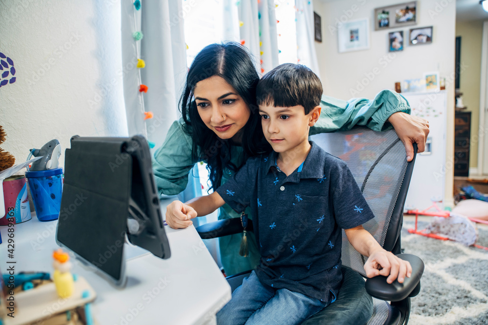 Mom helping son look at something on iPad tablet computer