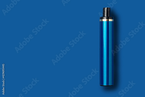 Disposable e-cigarette on blue isolated background. The concept of modern smoking, vaping and nicotine. Top view