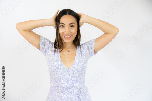 Young woman covering her ears with hands over white background © Danko