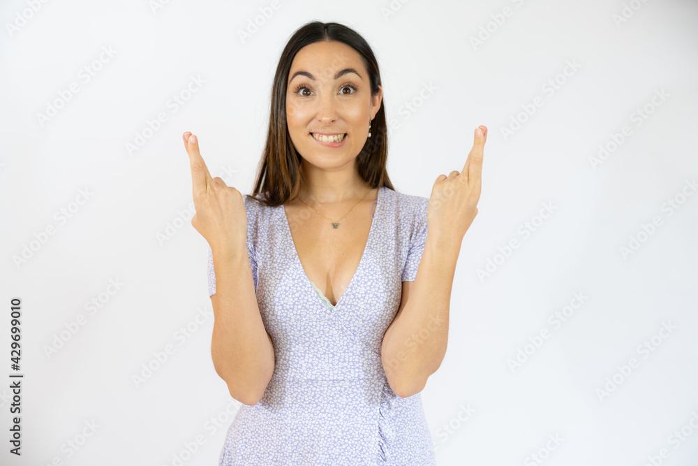 Portrait of a smiling young woman showing fingers crossed for good luck isolated white background Portrait of a smiling young woman showing fingers crossed for good luck isolated white background