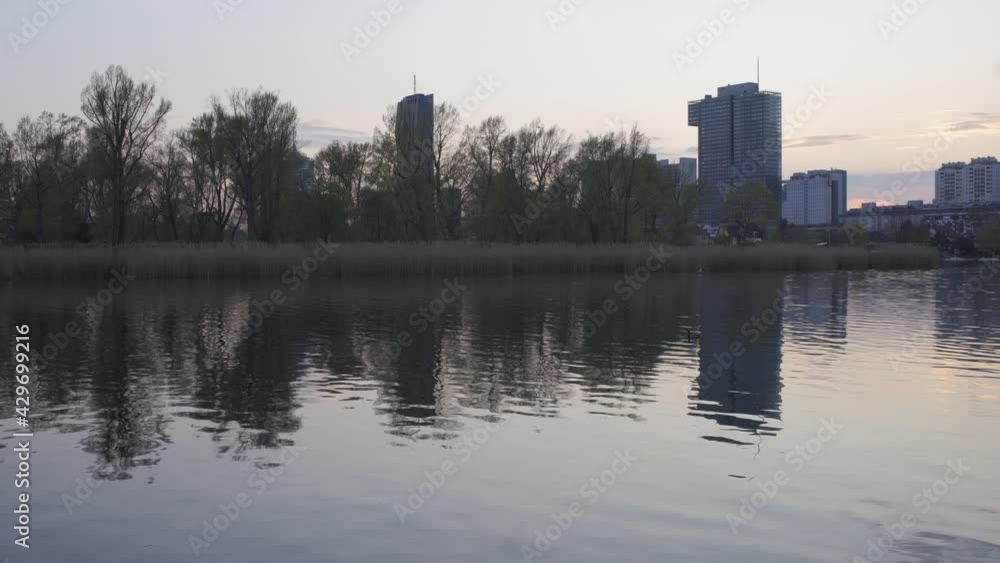 Kaisermühlen, a district in Vienna's 22nd district, viewed from the old Danube with reflections in the river Kaisermühlen, a district in Vienna's 22nd district, viewed from the old Danube with reflections in the river