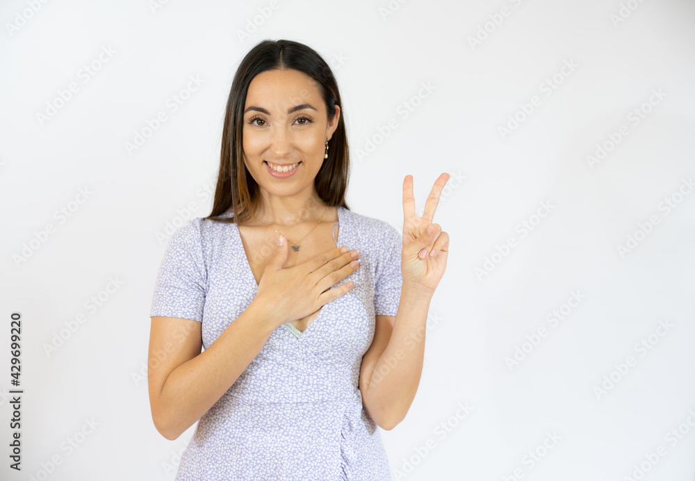 Young hispanic woman isolated showing victory sign and smiling broadly. Young hispanic woman isolated showing victory sign and smiling broadly.