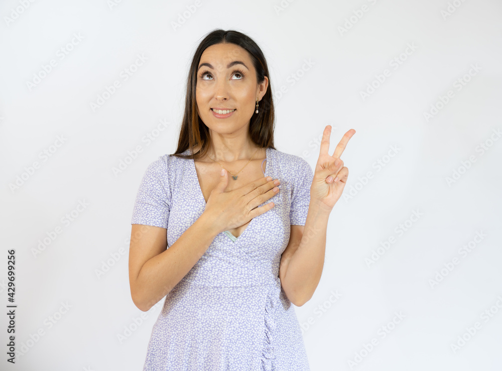 Young hispanic woman isolated showing victory sign and smiling broadly. Young hispanic woman isolated showing victory sign and smiling broadly.
