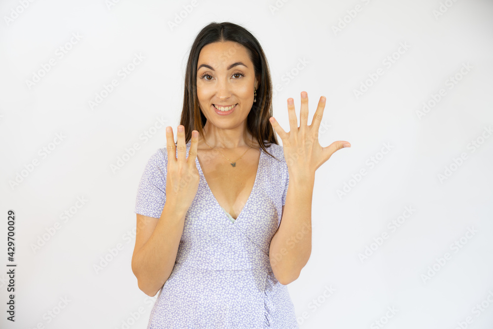 Smiling woman in casual dress counting eight over white background Smiling woman in casual dress counting eight over white background