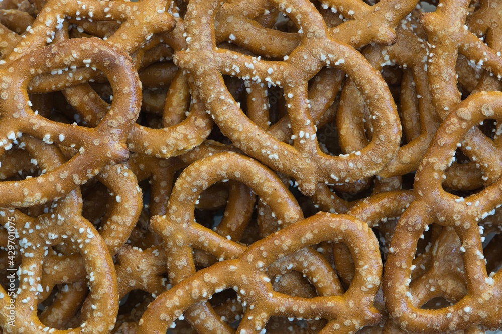 Many salted pretzels scattered loosely, close up directly above. Savory pastry snack traditionally made in Germany and France. Many salted pretzels scattered loosely, close up directly above. Savory pastry snack traditionally made in Germany and France.