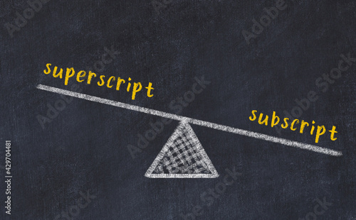 Concept of balance between superscript and subscript. Chalk scales and words on it photo