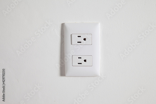 Isolated north american power outlet plug in socket on a white wall background 