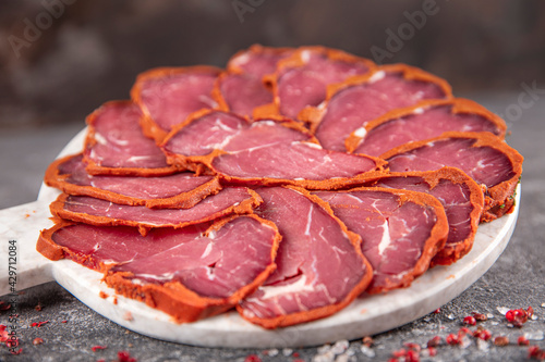 Turkish bacon, pastrami ( kayseri pastirma ) Fresh sliced pastrami. Pastrami ( dried meat with spices ). beef bacon sliced. traditional turkish food pastirma. photo