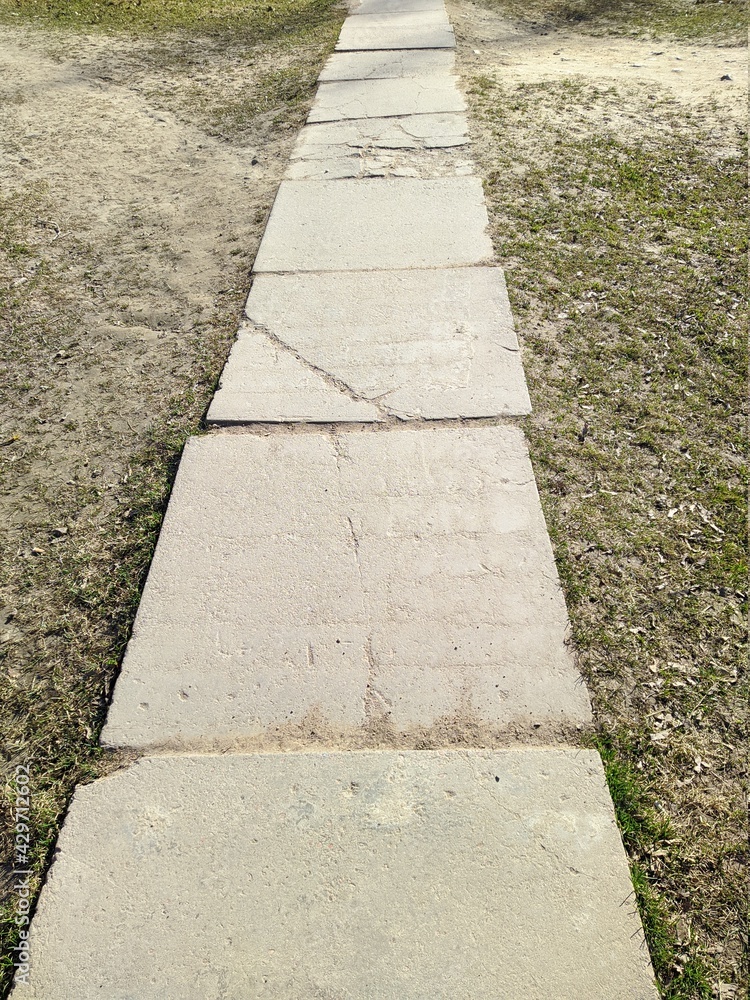 Obraz premium path in the park is made of concrete square slabs